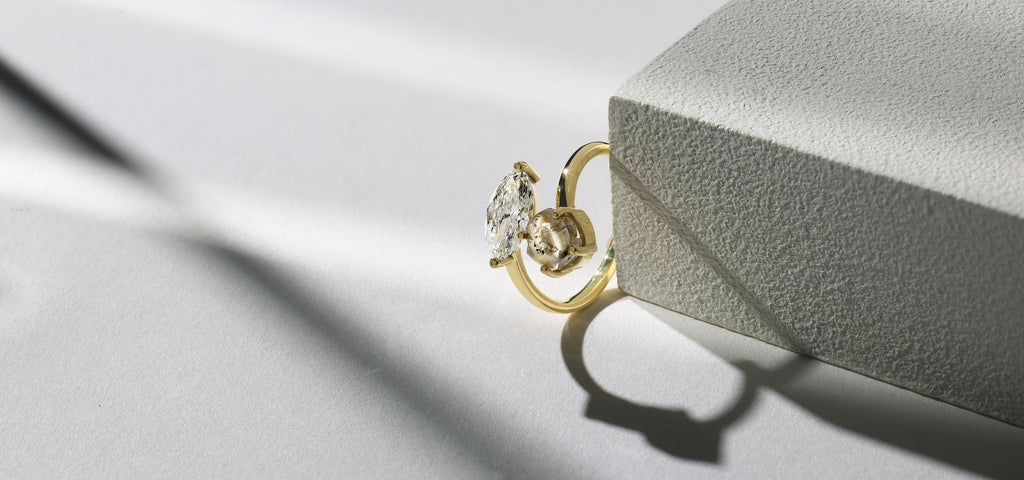 A yellow gold engagement ring featuring a rough diamond set in a unique custom design