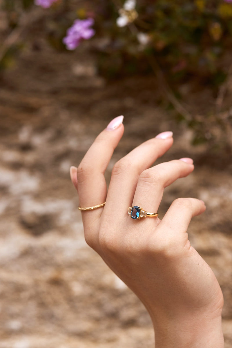 Blue cushion cut sapphire engagement ring with baguette sidestones with matching twig band