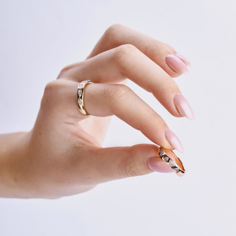 raw diamond wedding bands on model hands