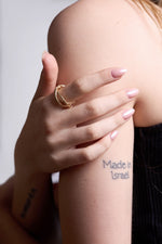 Weaved gold band on model with tattoo