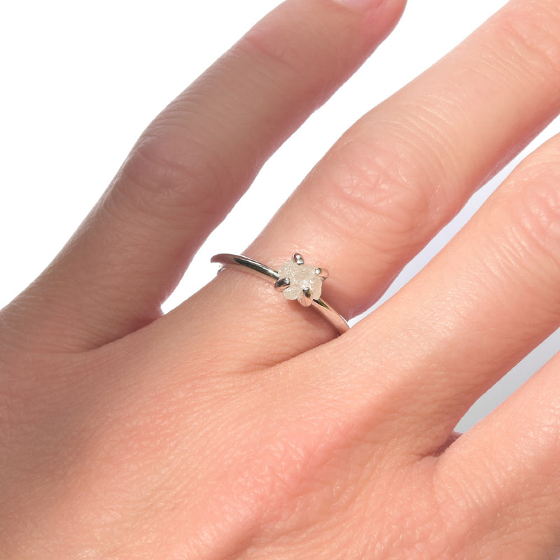Rough diamond engagement ring in a delicate setting of 14k white gold and four prongs.