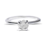 Raw diamond engagement ring in a delicate setting of 14k white gold and four prongs.