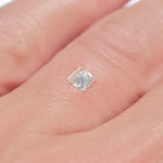 0.24 carat half octahedron white raw diamond on finger