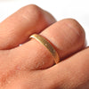 Brushed natural gold wedding band with embedded diamonds