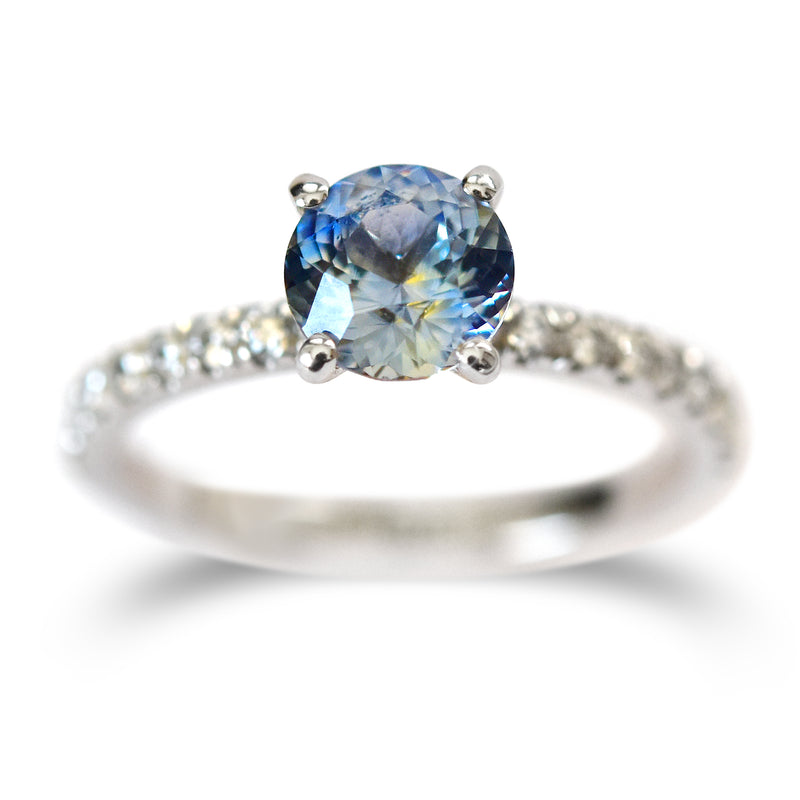 A sapphire engagement ring with four prongs and diamond melee on the band