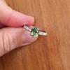 Oval jungle green sapphire held by four prongs with melee