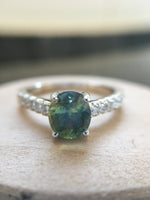 Oval jungle green sapphire held by four prongs with melee
